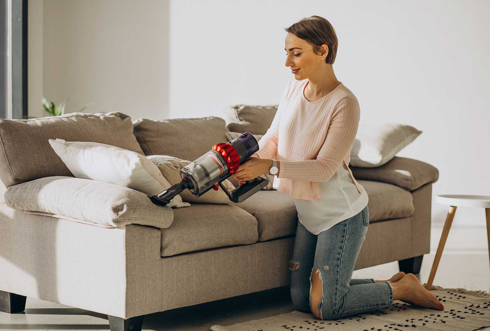 Foto Una persona que usa una aspiradora para limpiar un sofá